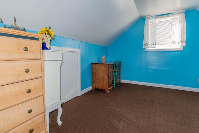 interior space with dark carpet and vaulted ceiling