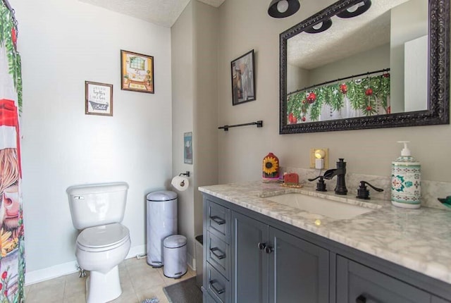 bathroom with toilet, tile patterned flooring, a textured ceiling, and vanity