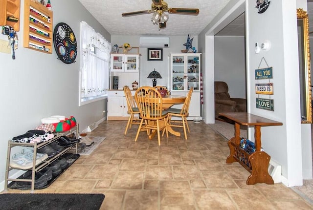 dining space with a wall unit AC, ceiling fan, and a textured ceiling