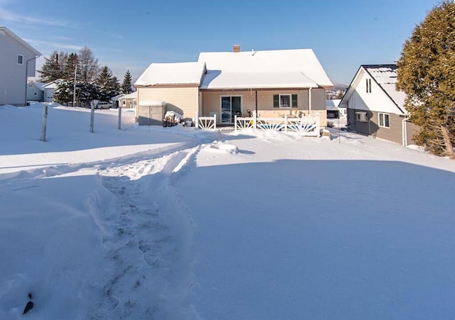 view of snow covered rear of property