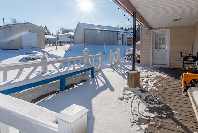 snow covered patio featuring a storage shed