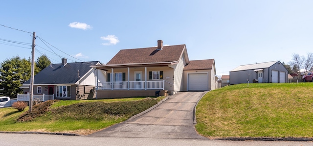 186 Mountain View Ave, Madawaska, ME 04756 - view of front of home with a porch, asphalt driveway, a garage, a front lawn, and a chimney
