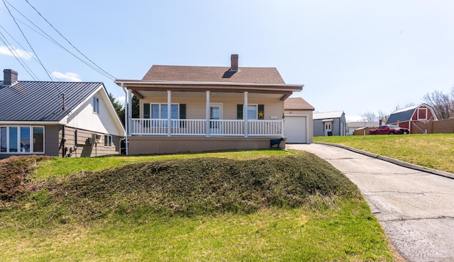 186 Mountain View Ave, Madawaska, ME 04756 - view of front of house with covered porch, a chimney, asphalt driveway, a garage, and a front lawn