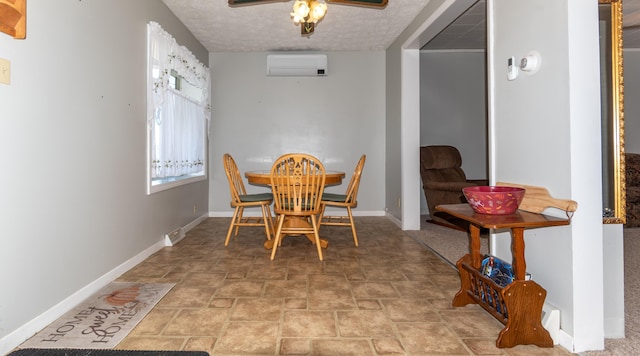 186 Mountain View Ave, Madawaska, ME 04756 - dining room with a wall mounted air conditioner, baseboards, stone finish floors, a ceiling fan, and a textured ceiling