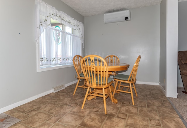 186 Mountain View Ave, Madawaska, ME 04756 - dining room with a wall unit AC, baseboards, stone finish floors, and a textured ceiling