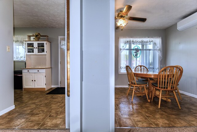 186 Mountain View Ave, Madawaska, ME 04756 - dining area featuring stone finish flooring, a textured ceiling, baseboards, and a wall mounted AC