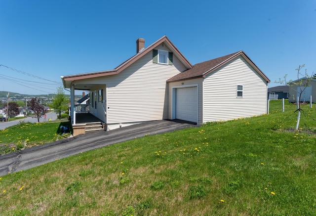 186 Mountain View Ave, Madawaska, ME 04756 - view of side of home featuring a chimney, a yard, a garage, and a porch