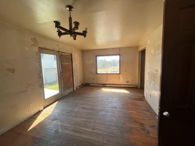 98 White Schoolhouse Rd, Corinth, ME 04427 - empty room featuring a baseboard radiator, an inviting chandelier, and wood finished floors