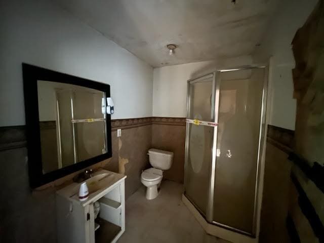 98 White Schoolhouse Rd, Corinth, ME 04427 - full bathroom with toilet, tile walls, wainscoting, and a stall shower