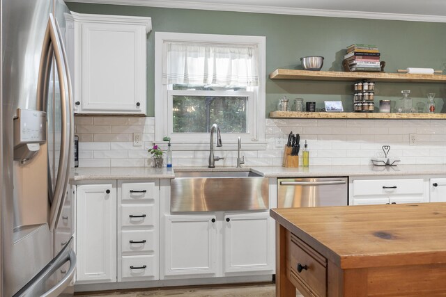 16 Hayden Hill Rd, Litchfield, ME 04350 - kitchen featuring appliances with stainless steel finishes, a sink, decorative backsplash, crown molding, and white cabinetry