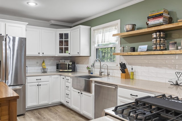 16 Hayden Hill Rd, Litchfield, ME 04350 - kitchen with stainless steel appliances, crown molding, white cabinetry, open shelves, and a sink
