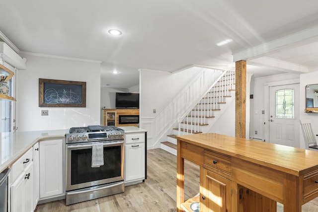 16 Hayden Hill Rd, Litchfield, ME 04350 - kitchen with stainless steel range with gas cooktop, ornamental molding, light wood finished floors, white cabinetry, and butcher block counters