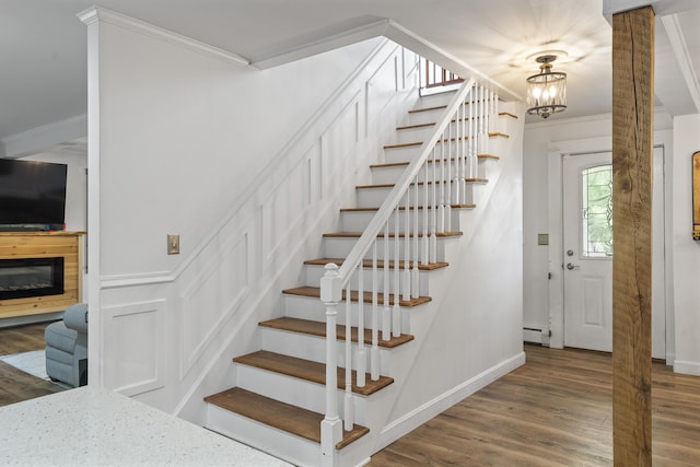 16 Hayden Hill Rd, Litchfield, ME 04350 - stairway featuring crown molding, wood finished floors, a baseboard radiator, a chandelier, and baseboards
