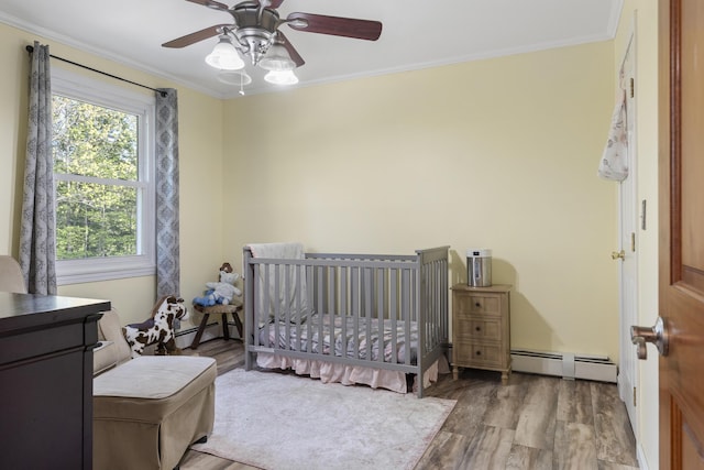 16 Hayden Hill Rd, Litchfield, ME 04350 - bedroom with a baseboard heating unit, wood finished floors, ornamental molding, and ceiling fan