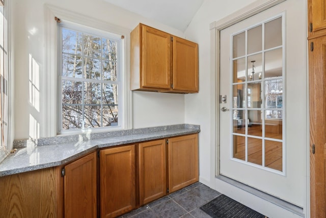 kitchen featuring vaulted ceiling and light stone countertops