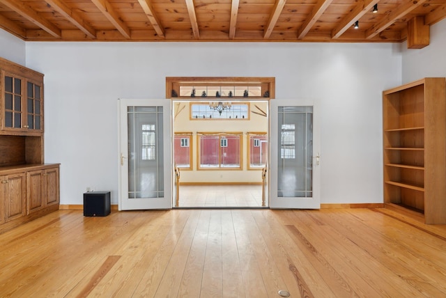 unfurnished living room with light hardwood / wood-style floors, french doors, and wood ceiling