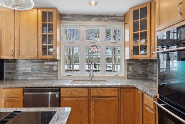 kitchen featuring sink, dishwasher, light stone countertops, and backsplash