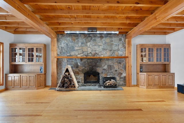 unfurnished living room with light hardwood / wood-style floors, wooden ceiling, beamed ceiling, and a fireplace