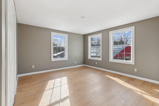 spare room featuring plenty of natural light and light hardwood / wood-style flooring