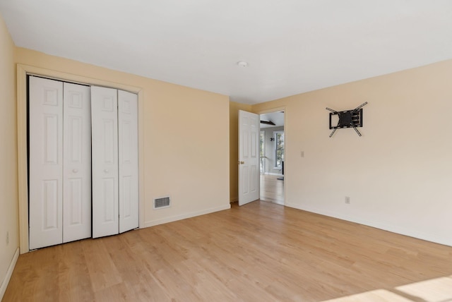 unfurnished bedroom featuring a closet and light wood-type flooring