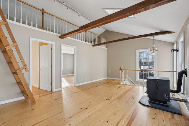 exercise room featuring track lighting, vaulted ceiling, and wood-type flooring