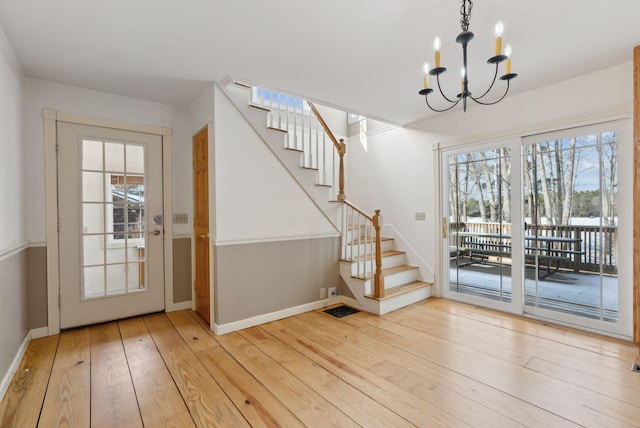 doorway featuring a notable chandelier and light wood-type flooring