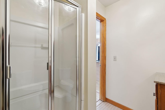 bathroom with vanity, a shower with shower door, and tile patterned floors