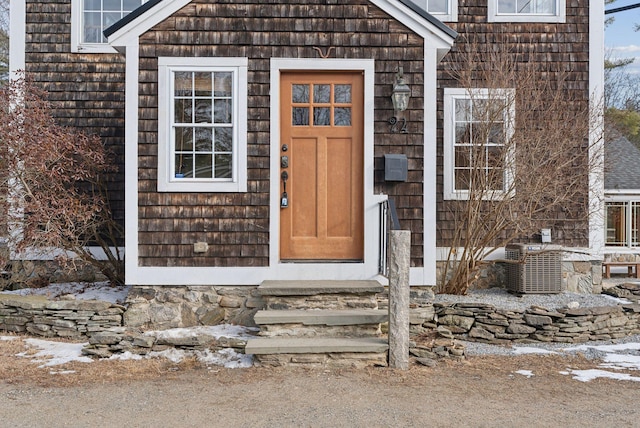 snow covered property entrance with central AC