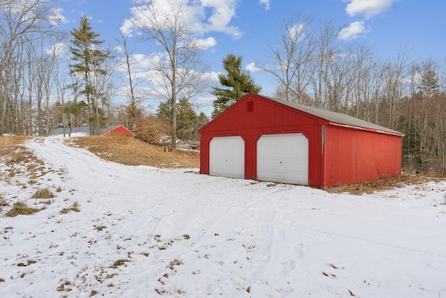 snow covered structure featuring a garage