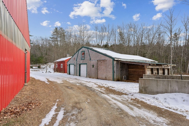 snow covered structure with a garage