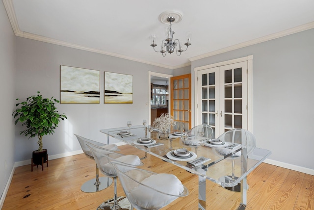 dining area with a chandelier, light hardwood / wood-style flooring, french doors, and ornamental molding