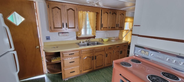 kitchen featuring sink, white refrigerator, and range