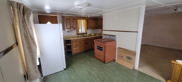 kitchen with stove, sink, and white refrigerator