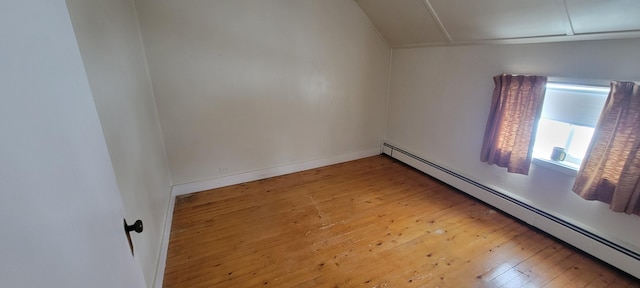 spare room featuring a baseboard heating unit and light wood-type flooring