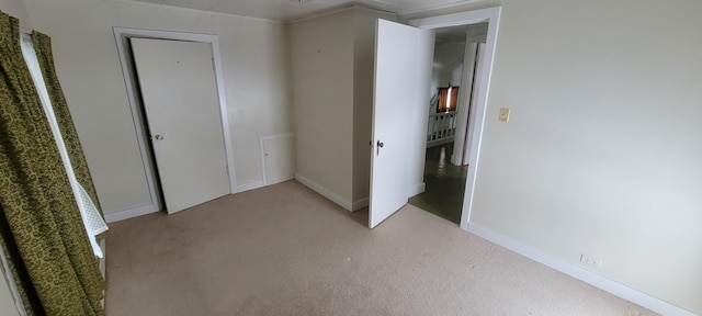 unfurnished bedroom featuring light colored carpet and ornamental molding