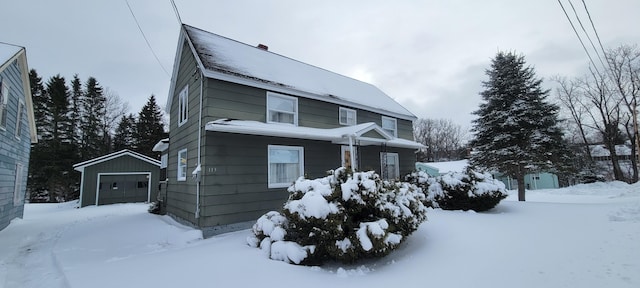 view of front of home with a garage and an outbuilding