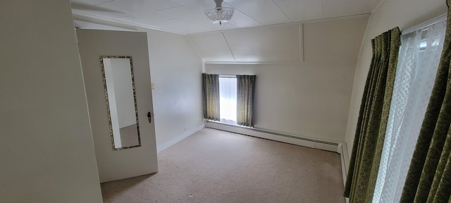 empty room with light carpet, vaulted ceiling, and baseboard heating