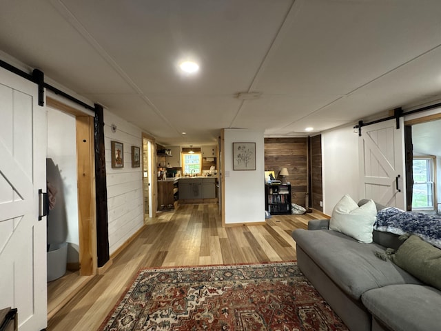 62 Main St, Hiram, ME 04041 - living area with a barn door, light wood-type flooring, wooden walls, and recessed lighting