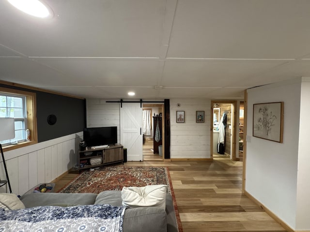 62 Main St, Hiram, ME 04041 - living room with a barn door, light wood-style flooring, and wooden walls