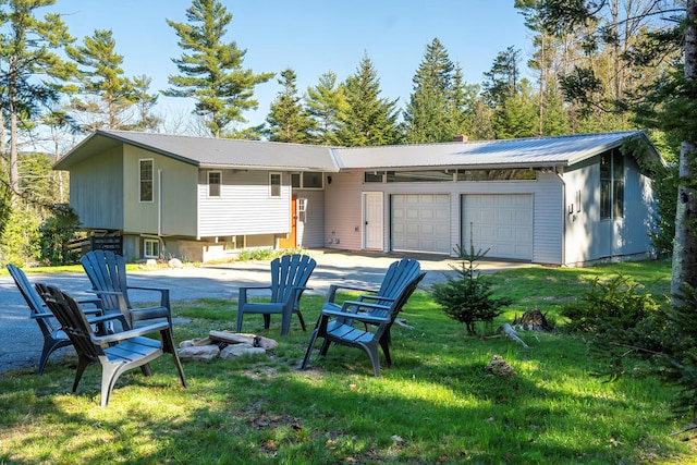 back of property with a lawn and a garage