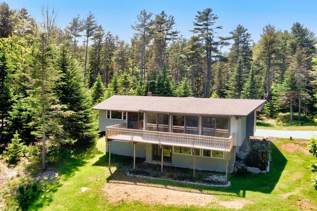 back of property featuring a yard and a sunroom