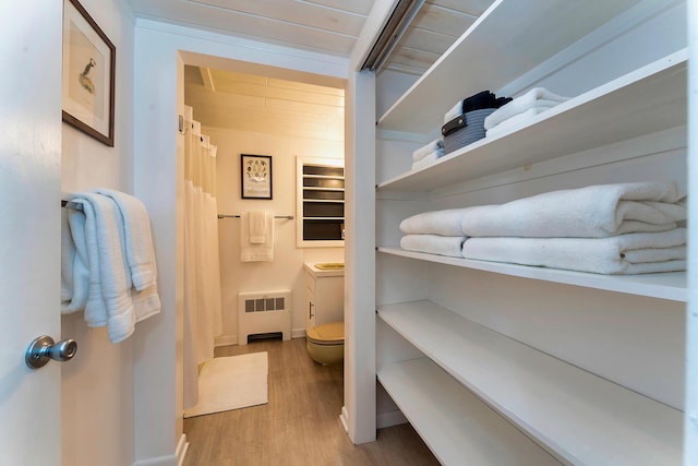 bathroom featuring hardwood / wood-style floors, toilet, radiator heating unit, and vanity