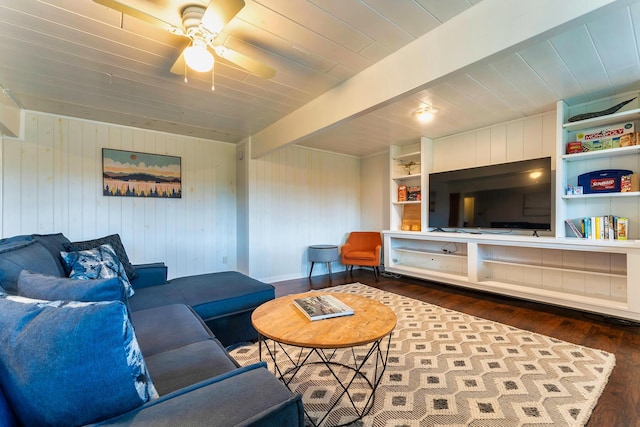 living room featuring wood walls, ceiling fan, dark wood-type flooring, built in features, and beam ceiling