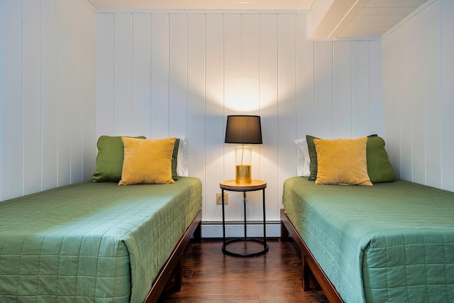 bedroom with dark wood-type flooring and a baseboard heating unit