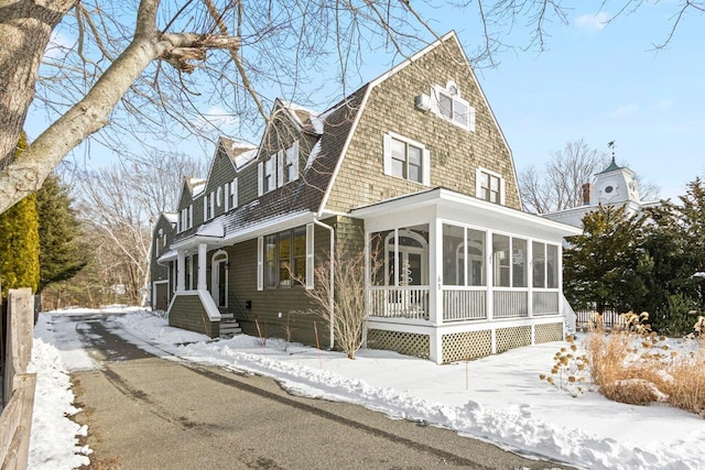 view of snow covered exterior featuring a sunroom