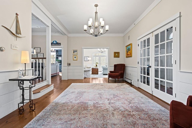 sitting room with ornamental molding, dark hardwood / wood-style floors, a chandelier, and french doors