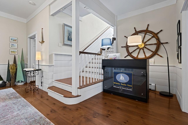 staircase featuring crown molding, a baseboard radiator, and hardwood / wood-style flooring