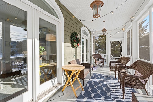 sunroom / solarium with a healthy amount of sunlight and wooden ceiling