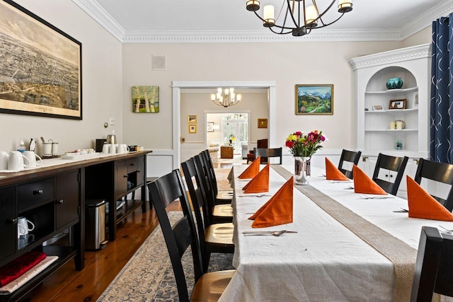 dining room with dark hardwood / wood-style flooring, crown molding, built in features, and a chandelier