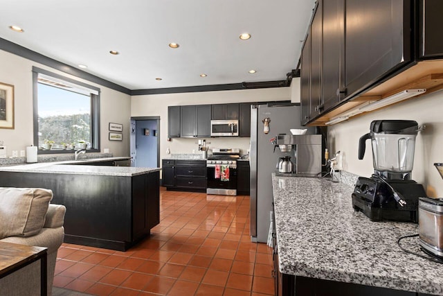 kitchen featuring stainless steel appliances, dark tile patterned floors, sink, and light stone counters